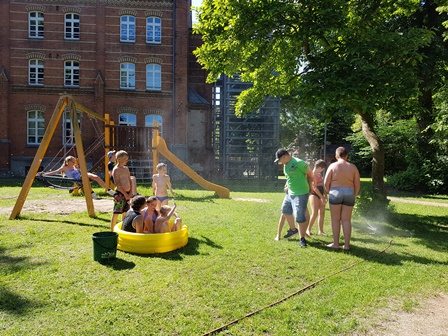 Kinder spielen mit Wasser im Garten